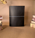 black leather journal on a brown backround