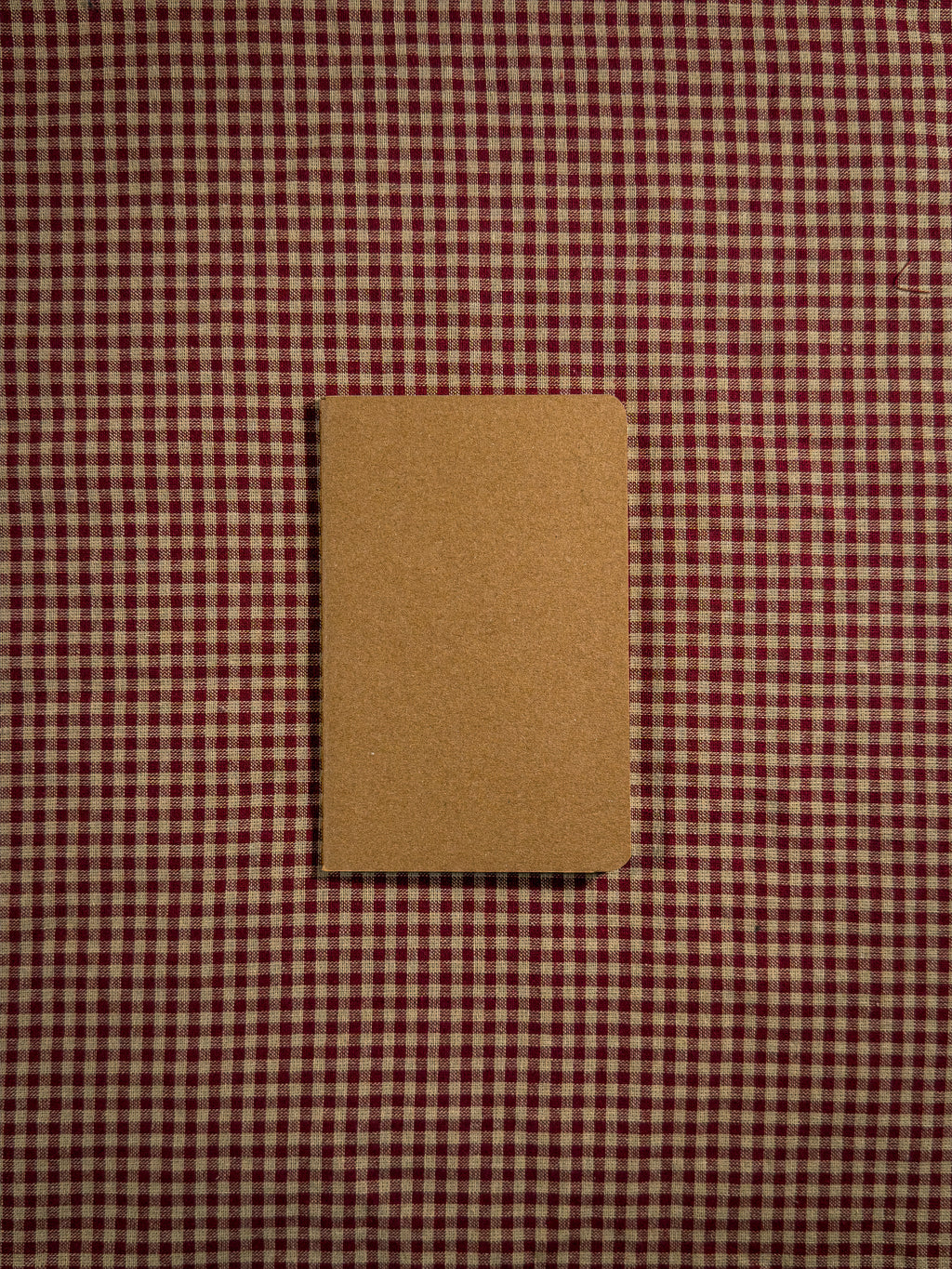 A small brown pocket sized paper notebook sized at 3" x 5.5"