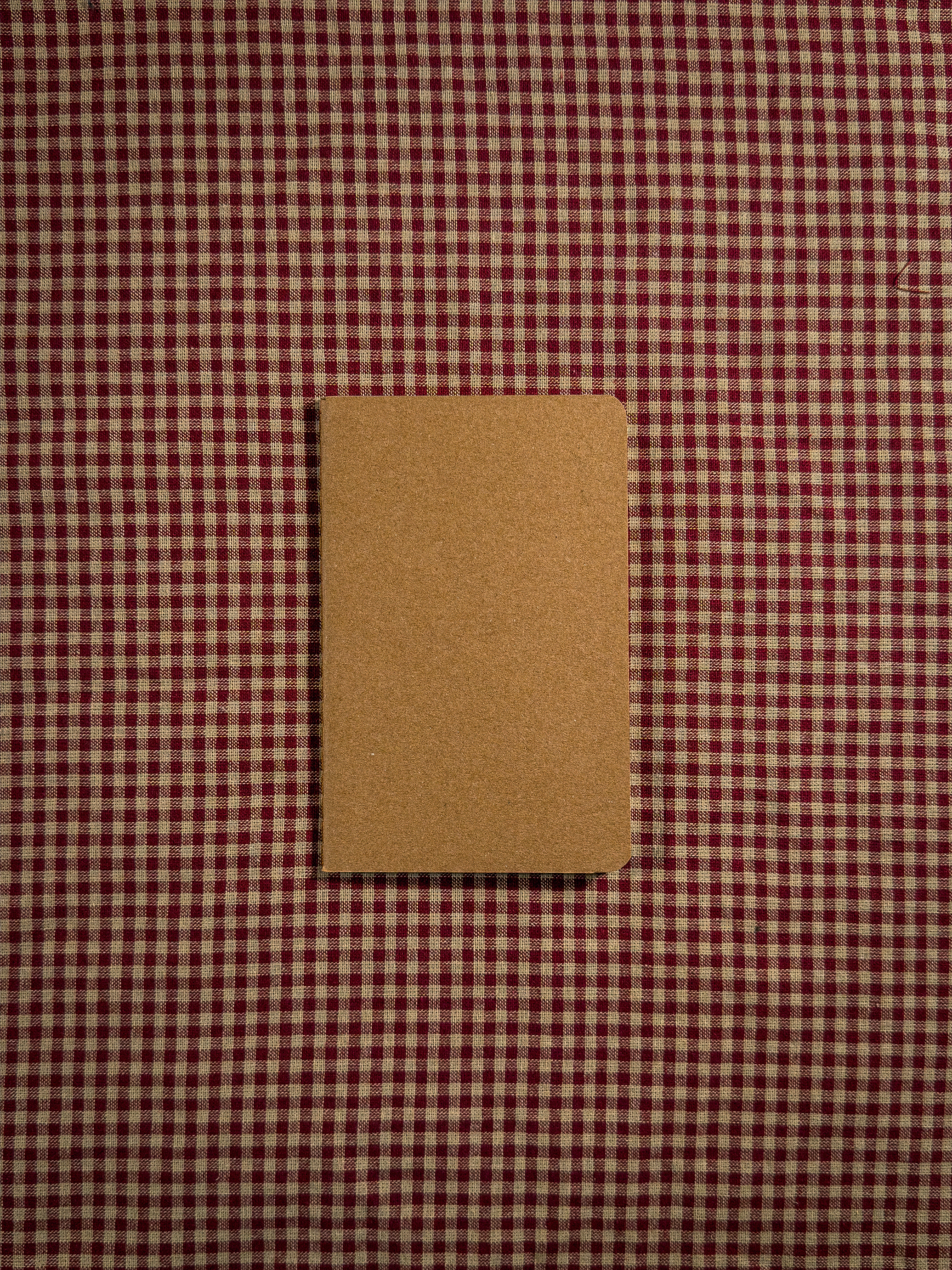 A small brown pocket sized paper notebook sized at 3" x 5.5"